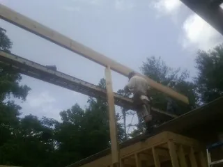 Carpenter setting a ridge beam over a new addition frame — Ice Dam Removal by Roofing Brothers in Hedrick