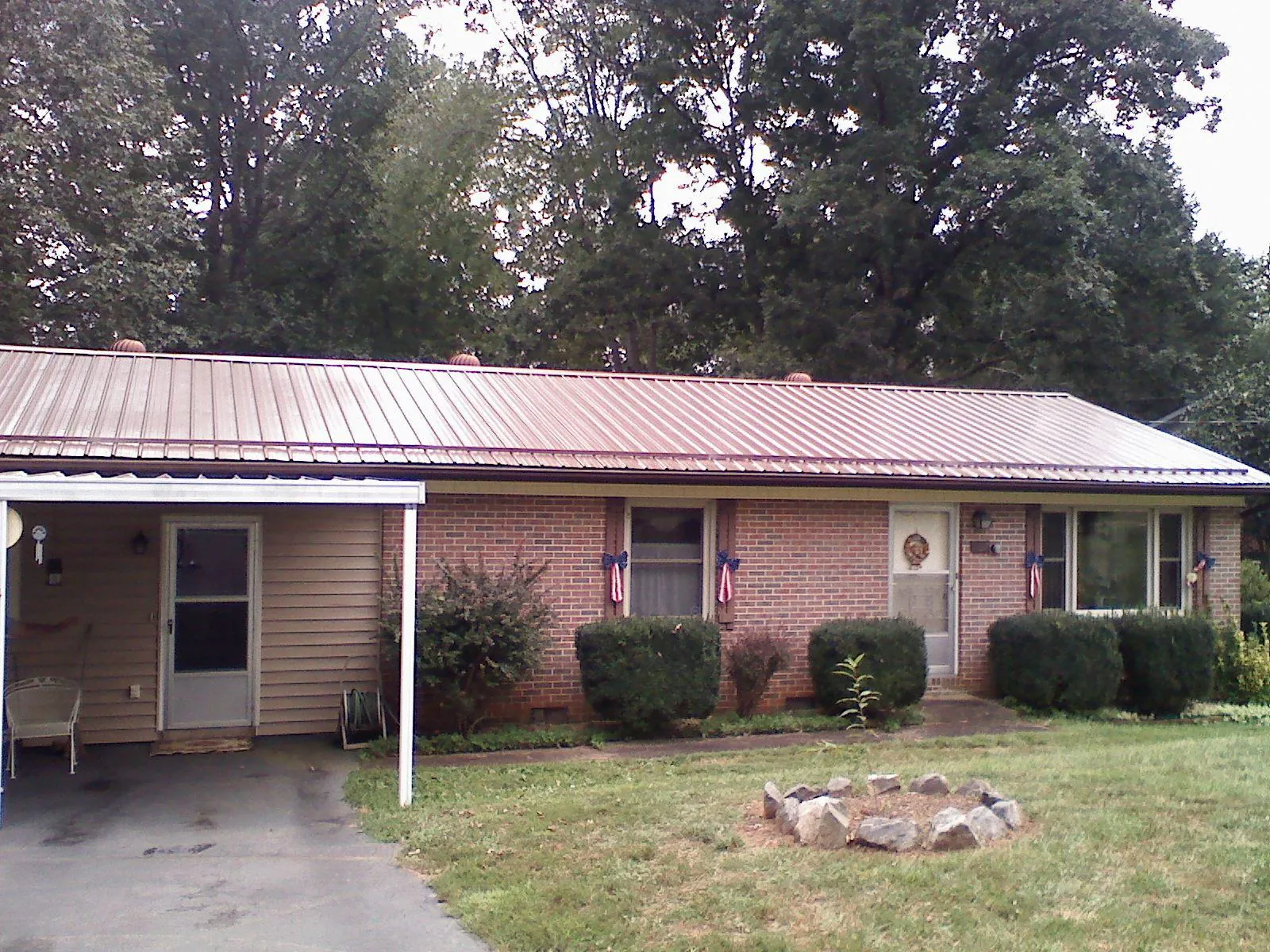 Bronze metal roof and carport on a brick ranch home — Roof Repair work by our crew in Hedrick